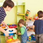 Madre y sus hijos limpiando los juguetes en su habitación