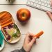 Escritorio con comida para llevar al trabajo como fruta y verduras