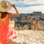 Mujer con vestido ligero admirando un escenario de Italia